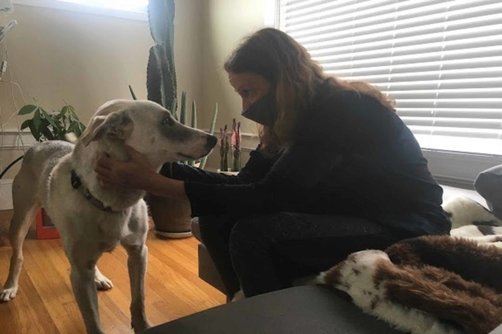 marji Pearson holding brown puppy face while healing